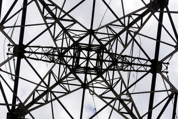 symmetrical pattern formed by a bottom view of a steel grid-shaped power line support