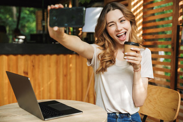Portrait of a playful young girl taking selfie