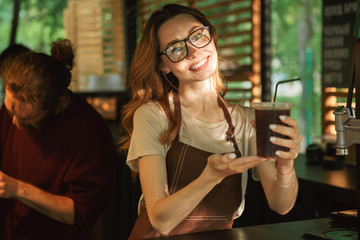 Portrait of a happy young barista girl in apron