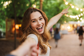Close up of cheerful young girl pointing away