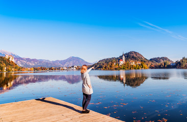 Travel Slovenia, Europe. Young woman looking at Bled Lake and Alps Mountain. Bled Lake is amazing tourist attractions. 