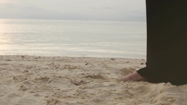 Foot of young girl in black maxi dress