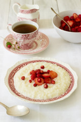 A useful breakfast of rice porridge with strawberry sauce served with tea.