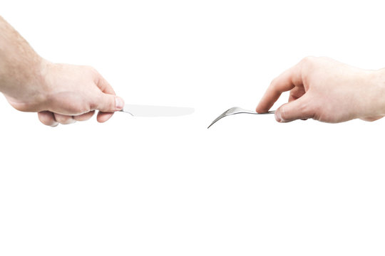 Male hands of the left-hand man hold a metal fork and knife, isolated on a white background, a first-person view