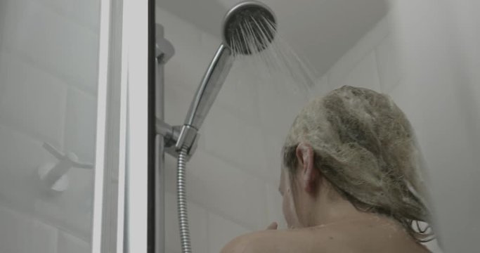 Pretty young woman taking a shower