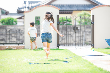 庭で水遊びをする女の子