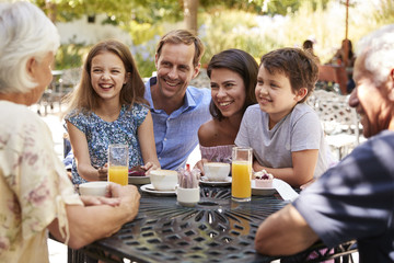 Multi Generation Family Enjoying Snack At Outdoor CafŽ Together