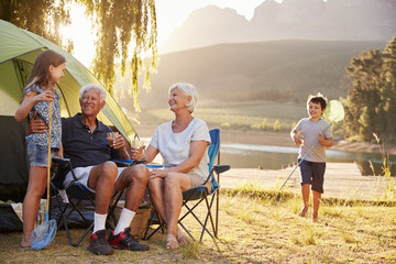 Grandchildren With Grandparents On Camping Holiday By Lake