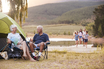 Multi Generation Family On Camping Trip By Lake Together