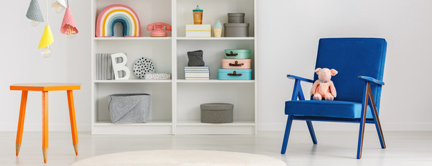 Colorful ice cream cones pendant lamps above a table with crayons legs in a fun and creative kid bedroom interior