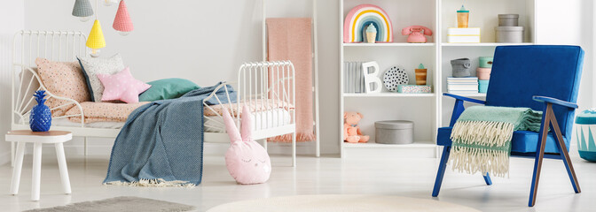 Header of a scandinavian bedroom interior for a child with cute pillows and toys, white furniture...