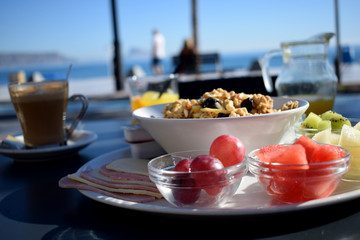 Desayuno saludable con frutas y muesli en una cafetería con vistas al mar