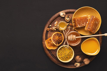 Various types of honey on wooden platter, closeup