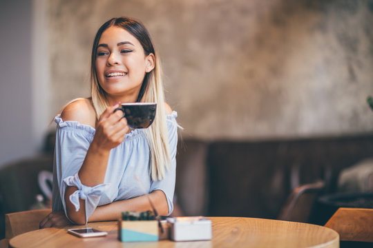 Young hispanic woman at cafe drinking coffee  