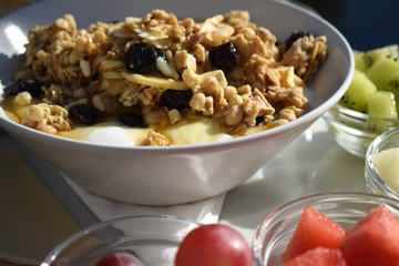 Desayuno saludable con frutas y cereales con yogur y miel en una cafetería con vista al mar