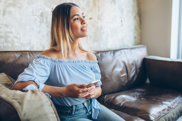 Woman sitting on the couch and using mobile phone