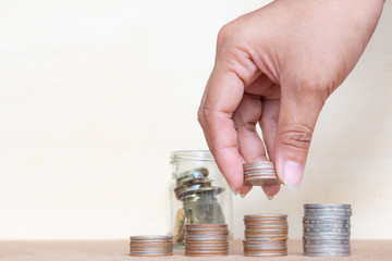 Saving money concept. Finger hold stack coins to arrangement with shown concept of growing business and wealthy.