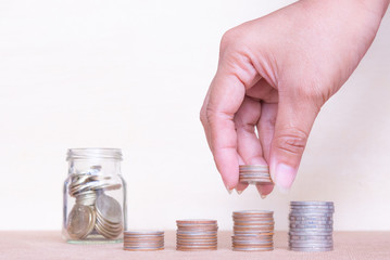 Saving money concept. Finger hold stack coins to arrangement with shown concept of growing business and wealthy.