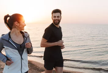 Foto op Plexiglas Smiling young couple jogging together © Drobot Dean