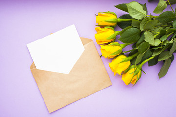 Bouquet of yellow roses, envelope and gifts. Congratulation, holiday, lifestyle concept. Space for a text. Top view. Close up.