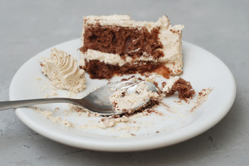 Piece of Bitten Chocolate Cake with White Cream Sweet Dessert Gray textured Background