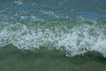 Soft wave of blue ocean on sandy beach. Background.