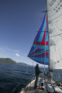 Flying a colorful spinnaker on a seaworthy sailing yacht