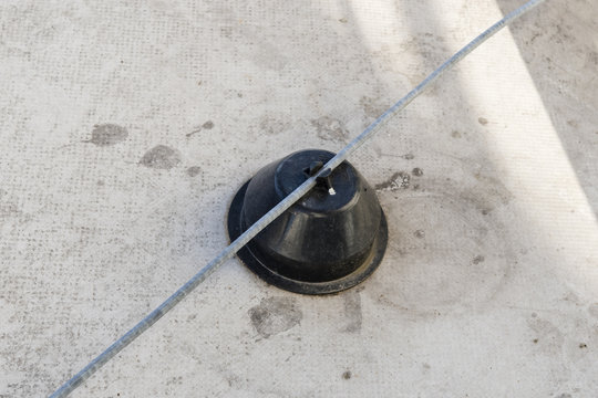 Plastic foot on the roof holding the wire of the lightning rod.