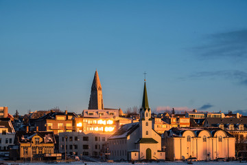 Obraz premium Beautiful shot of Reykjavik downtown with lutheran church in a golden evening light. Capital city of Iceland Reykjavik in winter.
