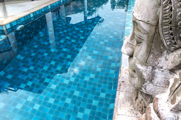 Buddha statue over the luxury swimming pool