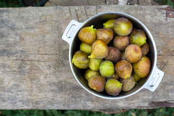 Green sweet figs bowl on old wooden desk. Harvest.