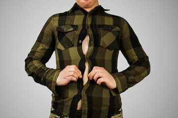 Young fat guy with small green checkered shirt on gray background