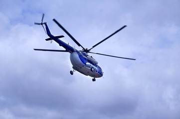 Fototapeta na wymiar White blue helicopter on the sky background.