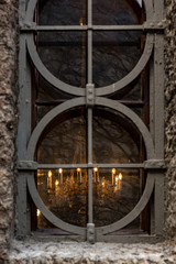 Old and aged, historic church window with stone frame and grids. Beautiful church chandelier. Light and hope concept.