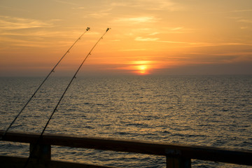 fishing rods on a background of sunset on the Baltic Sea, Kaliningrad.