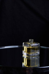Yellow bottle of perfume spraying, isolated on black background