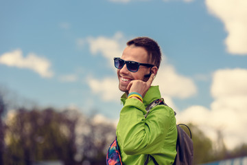 Smiling happy tourist talking on phone with bluetooth headset device