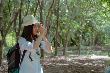 attractive woman adventure hiker go to trekking in the forest sightseeing natural at holiday travel concept. photographer using camera take a photo.