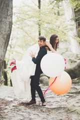 Obraz na płótnie Canvas Young funny happy wedding couple outdoors with ballons