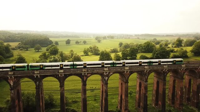 Aerial of a train riving over The Ouse Valley Viaduct across the river Ouse in Sussex England 