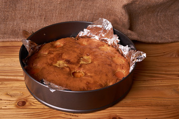 Apricot cake baked in foil on a wooden table. tasty pie food photo