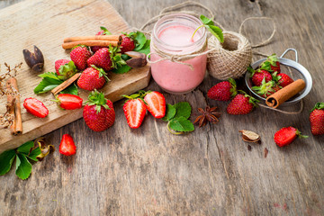Strawberry smoothies in glass with many strawberries on wooden background. Top view. Copy space