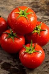 Fresh red tomatoes with waterdrops on wooden background