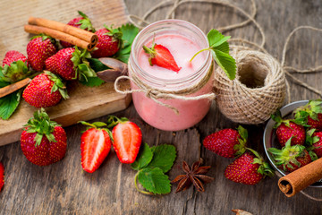 Strawberry smoothies in glass with many strawberries on wooden background. Top view. Copy space