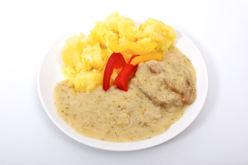 Seitan with dill sauce and potatoes on a white