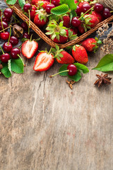 Fresh sweet cherries and strawberries on wooden background. Top view. Copy space. Flatlay