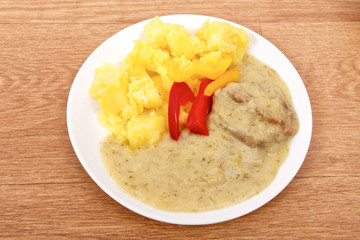 Seitan with dill sauce and potatoes on a table