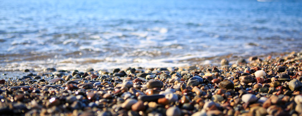 Waves washing over gravel beach, macro shot.