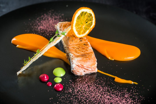 grilled salmon fish under the souce un black background