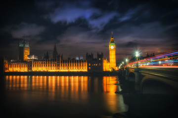 Big Ben at night with the lights of the cars in London city, UK.